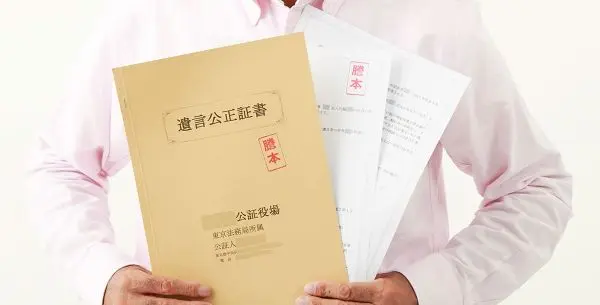 遺言公正証書を手に持っているの写真